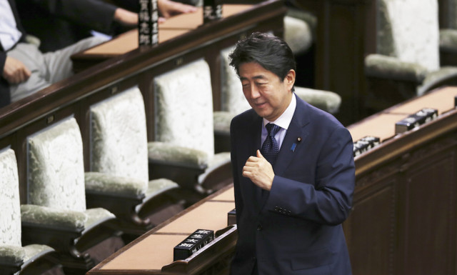 Japanese Prime Minister Shinzo Abe smiles and during the lower house plenary diet session in Tokyo Friday Sept. 18 2015