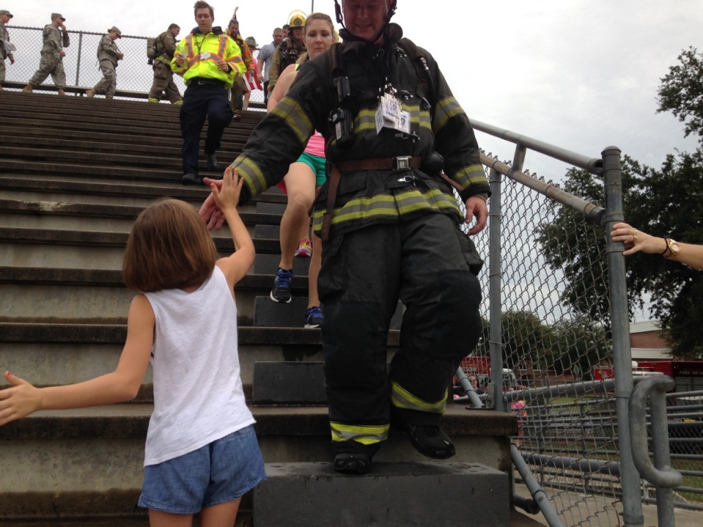 Madison Whitmeyer 9 high-fives a firefighter during Citrus County's 9/11 Memorial Stair Climb on Saturday. The event remembered the victims of Sept. 11 2001 attacks in New York City