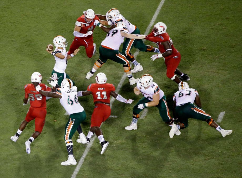 Miami quarterback Brad Kaaya center left looks to pass during the first half of an NCAA college football game against Florida Atlantic Friday Sept. 11 2015 in Boca Raton Fla