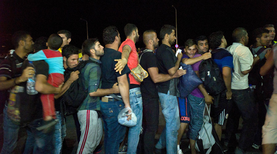 Refugees and migrants line up to board the passenger ship'Eleftherios Venizelos heading to the port of Piraeus at the port on the island of Lesbos Greece