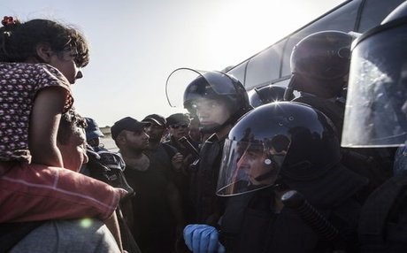 Migrants are prevented from boarding a bus by riot police at the border between Serbia and Croatia on Thursday. AP