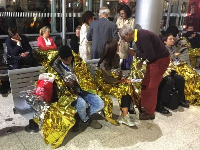 Passengers wrapped in thermal foil blankets given out by emergency services after their Eurostar train was stranded at Calais Station after intruders were seen near the Eurotunnel in Calais France