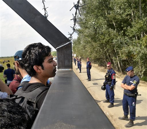 Migrants look through the border fence between Serbia and Hungary near Horgos Serbia on Tuesday