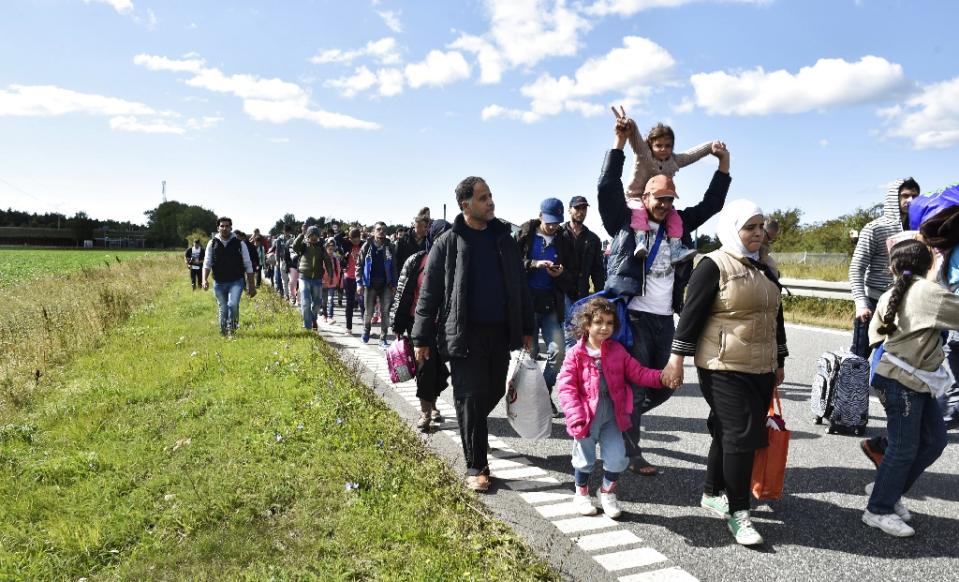 Migrants mainly from Syria walk on a highway north of Rodby Denmark