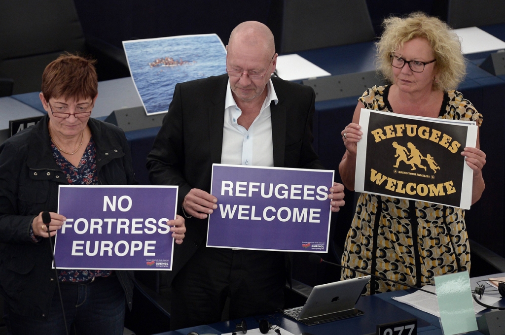 Members of European Parliament hold banners reading'no fortress Europe during a debate on the unprecedented flow of migrants and refugees at the European Parliament in Strasbourg eastern France