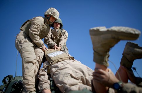 Marine Lance Cpls. Julia Carroll and Paula Pineda lift'Carl — a 220-pound test dummy — during training in March in California. Female Marines have completed months of training and are now waiting to hear whether they will be allowed to serve