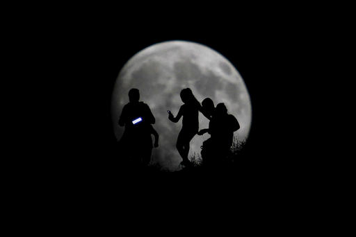 A group of hikers are seen silhouetted against the moon in Tijuana Mexico Aug. 27 2015