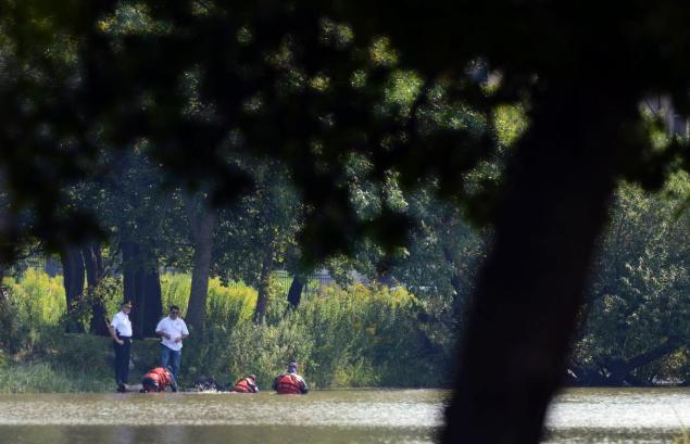 Chicago Police Marine Unit divers search a lagoon at Garfield Park after a toddler's decomposed feet and hand were found