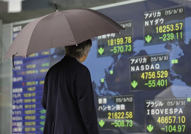 A man looks at an electronic stock indicator of a securities