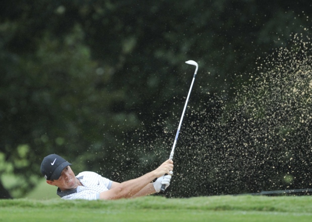 Rory Mc Ilroy hits out of a fairway bunker on the eighth hole