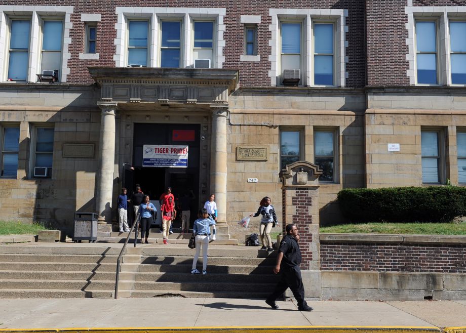 A security guard patrols in front of Wilkinsburg High School in Wilkinsburg Pa. Monday Sept. 21 2015 after students were released from school because a student poured gasoline on a security guard. A spokesman for a Pennsylvania school district says