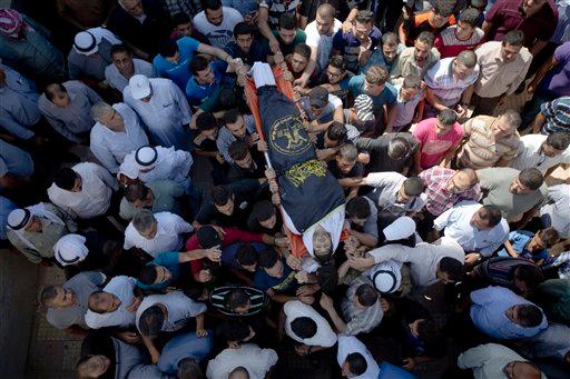 Palestinian mourners carry the body of Diyaa Talahmeh 21 covered with the flag of the Islamic Jihad militant group during his funeral in the West Bank village of Khursa near Hebron Tuesday Sept. 22 2015. Earlier Tuesday the military said a Palesti