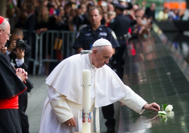 Pope Francis places a white rose at the South Pool of the 9/11 Memorial in downtown Manhattan Friday Sept. 25 2015 in New York