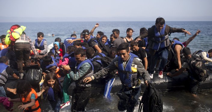 Syrian refugees jump off a dinghy as they arrive on the Greek island of Lesbos