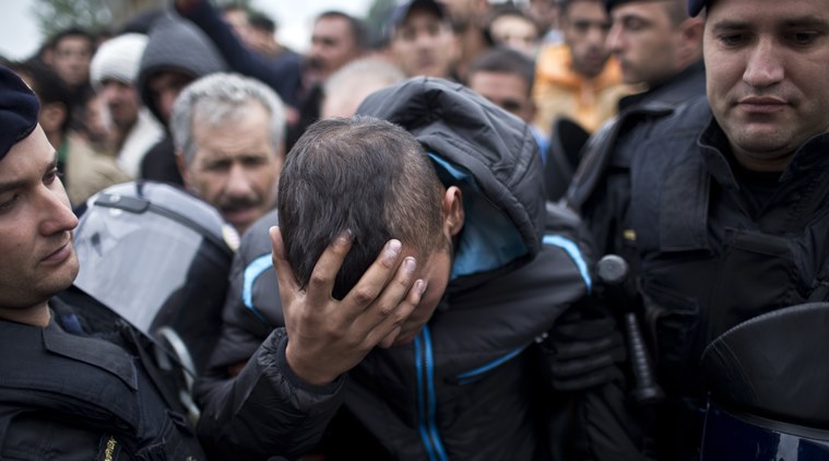 Croatian police officers support an injured man in front of a reception center in Opatovac Croatia Tuesday Sept. 22 2015. Scuffles have broken out between Croatian police and asylum-seekers after they were barred from entering a newly opened reception