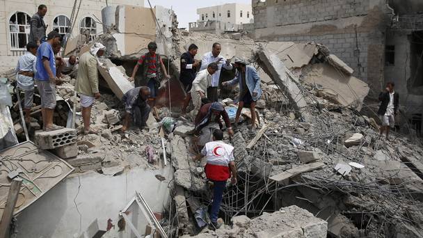 Rescue workers search for survivors after an air strike in Sanaa