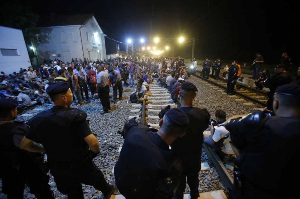 ReutersCroatian police stand guard in front of migrants at the train station in Tovarnik Croatia