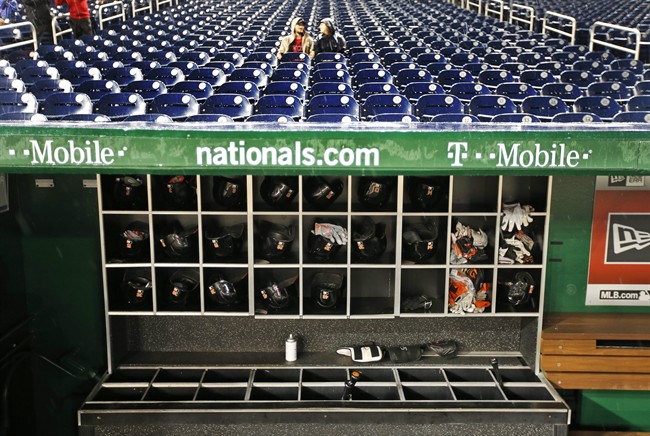 Fans sit in stands as rain falls before a baseball game between the Washington Nationals and the Baltimore Orioles at Nationals Park Monday Sept. 21 2015 in Washington. The game was postponed and is to be played Thursday Sept. 24. (AP