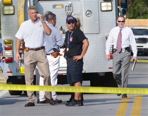 Okaloosa County Sheriff Larry Ashley far left and other sheriff's office personnel and emergency responders work at the scene of a law office in Shalimar Fla. where a deputy sheriff was shot Tuesday Sept. 22 2015. The suspect then fled to the