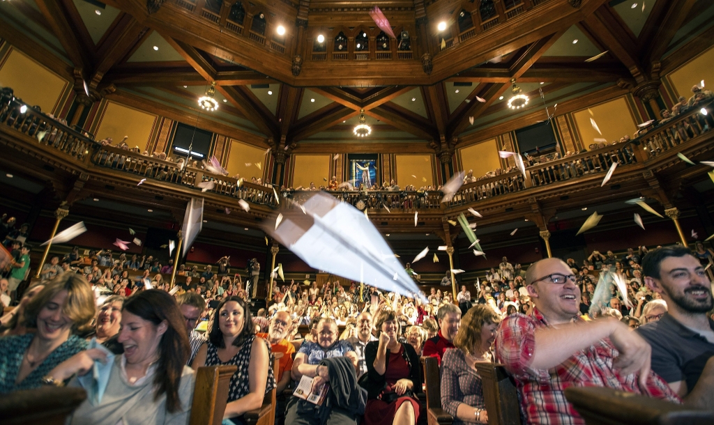 Spectators throw hundreds of paper airplanes at the stage during the 25th annual Ig Nobel awards