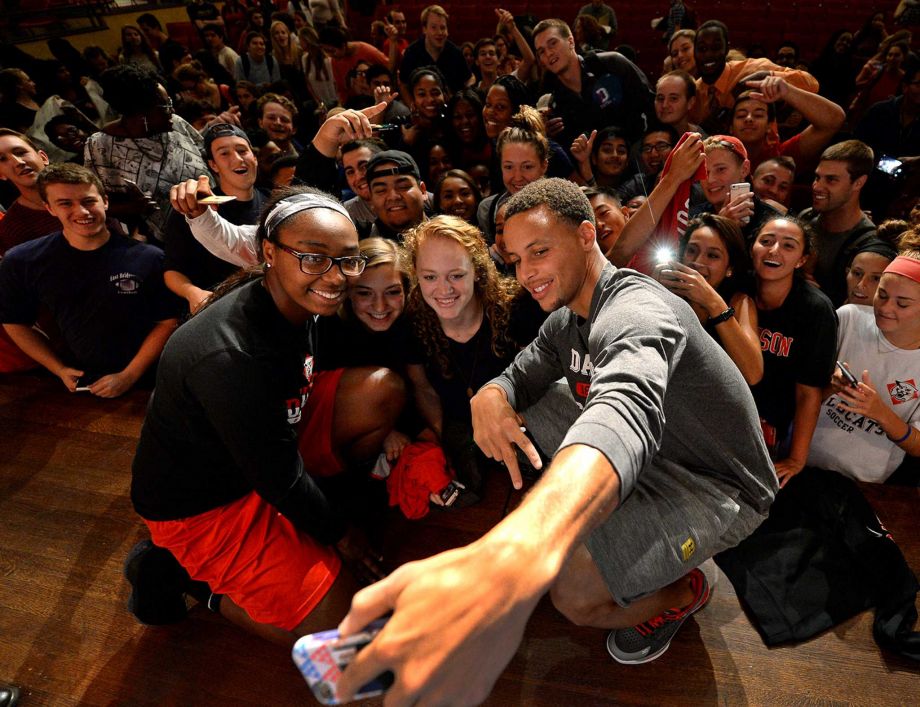 Davidson College women's basketball players Kyla Roland left Mackenzie Latt second from left and Hannah Early second from right pose for a selfie with former Davidson All American and NBA All Star Stephen Curry after Curry finished a question and