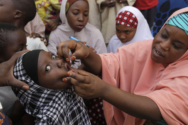 A health official administers a polio vaccine to a child in Kawo Kano Nigeria