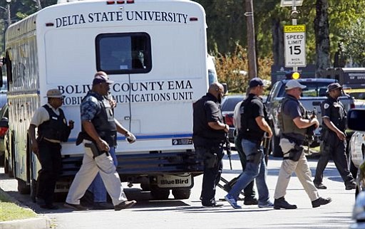 Law enforcement walk across the Delta State University campus to search for an active shooter in connection with a the shooting of history professor Ethan Schmidt in his office in Cleveland Miss. Monday Sept. 14 2015