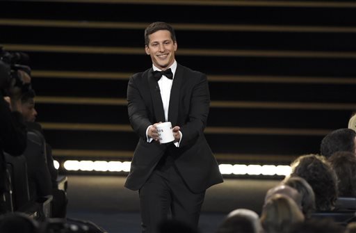 Host Andy Samberg prepares to present a coffee mug to Lorne Michaels at the 67th Primetime Emmy Awards on Sunday Sept. 20 2015 at the Microsoft Theater in Los Angeles