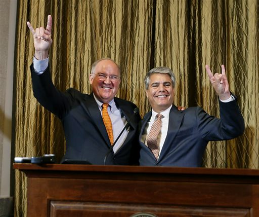 Interim athletic director Michael Perrin and University of Texas President Gregory Fenves sign the'hook em during a press conference Wednesday Sept. 16 2015 announcing Steve Patterson's replacement after his departure the day before at the Uni