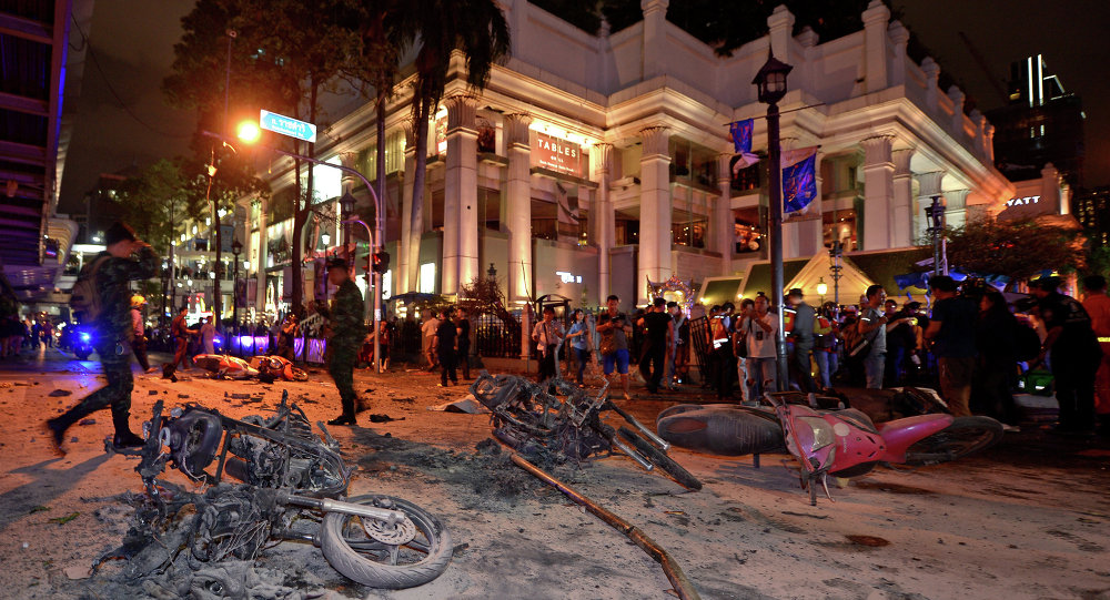 Thai soldiers inspect the scene after a bomb exploded