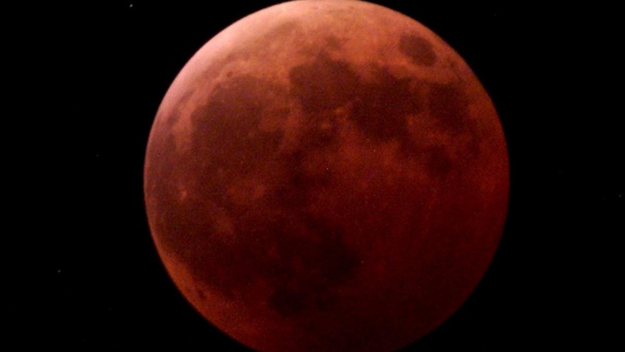 The moon appears totally covered by shadow during the lunar eclipse in this Jan. 9 2001 file