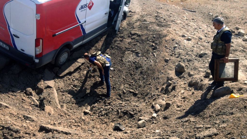 Turkish investigators search the site after a police minibus was destroyed in a bomb attack in Igdir on September 8