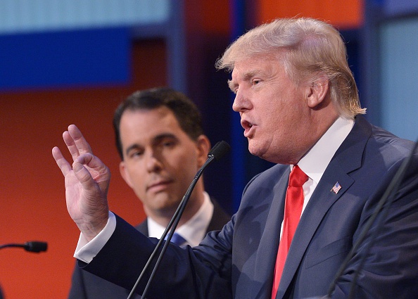 Wisconsin Governor Scott Walker listens as real estate tycoon Donald Trump speaks during the prime time Republican presidential debate