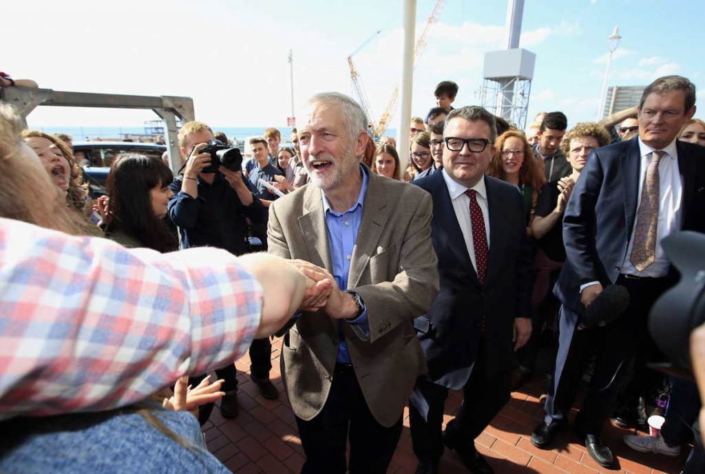 Labour party leader Jeremy Corbyn centre is greeted by supporters and the party's deputy leader Tom Watson centre right upon his arrival prior to the start of the annual Labour party conference at the Brighton Centre in Brighton