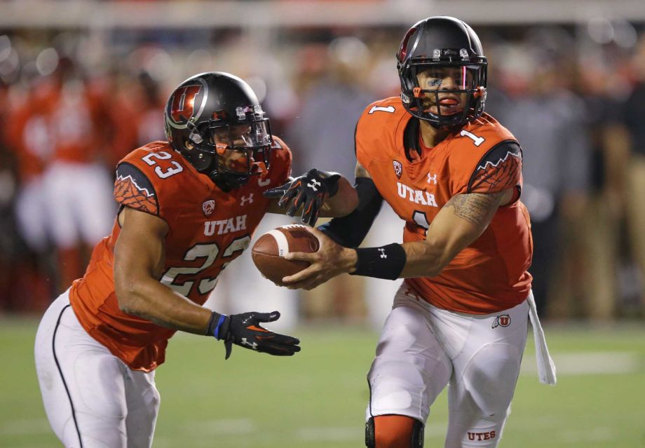 Utah quarterback Kendal Thompson hands the ball off to running back Devontae Booker during the second half of an NCAA college football game against Utah State on Friday Sept. 11 2015 in Salt Lake City. Utah won 24-14