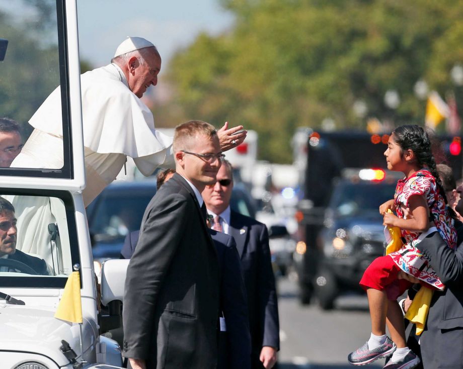 Pope Francis reaches to give a blessing to Sophie Cruz 5 from suburban Los Angeles during a parade in Washington. She also delivered a bright yellow T-shirt and a letter expressing wishes that her mother and father and