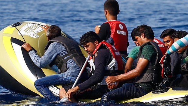 Migrants and refugees in a dinghy with a small motor paddle their craft after leaving Bodrum Turkey in the hopes of crossing the Mediterranean Sea to reach the Greek Island of Kos Sept. 19. Of the record total of 432,761 refugees and migrants making