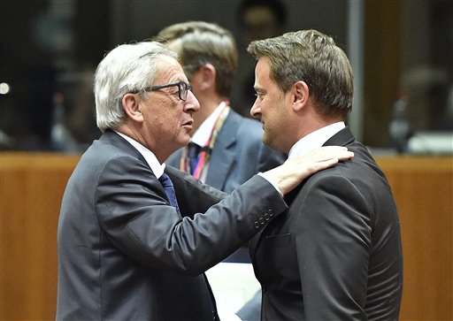 European Commission President Jean Claude Juncker left embraces Luxembourg's Prime Minister Xavier Bettel during an emergency EU heads of state summit on the migrant crisis at the EU Commission headquarters in Brussels on Wednesday Sept. 23 2015