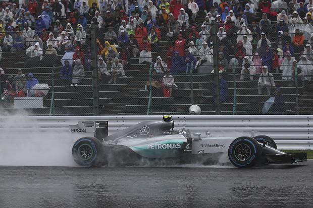 Spectators huddle in the rain as Rosberg drives his Mercedes across a soaked Suzuka track. He was second fastest overall
Rob Griffith