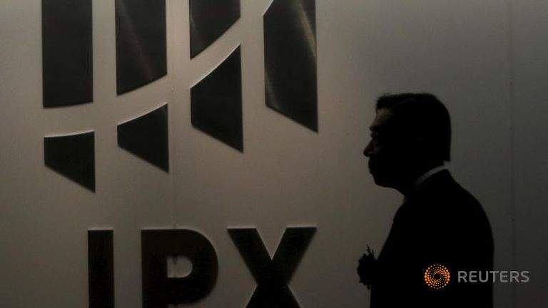 A man walks past the logo of Japan Exchange Group Inc. at the Tokyo Stock Exchange in Tokyo