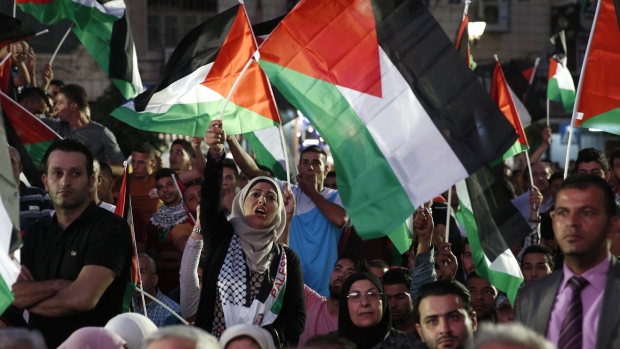 Palestinians wave their national flags as they wait for a live-screening of president Mahmoud Abbas's speech followed by the raising of the Palestinian flag at the UN headquarters in New York on Wednesday