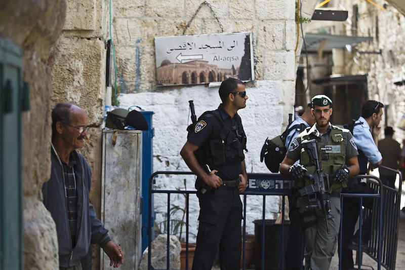 Israeli policemen stand guard at an entrance to Al Aqsa mosque in Jerusalem's Old City yesterday. Police say they will ban men under the age of 50 from attending Friday prayers at the mosque. – Reuters pic