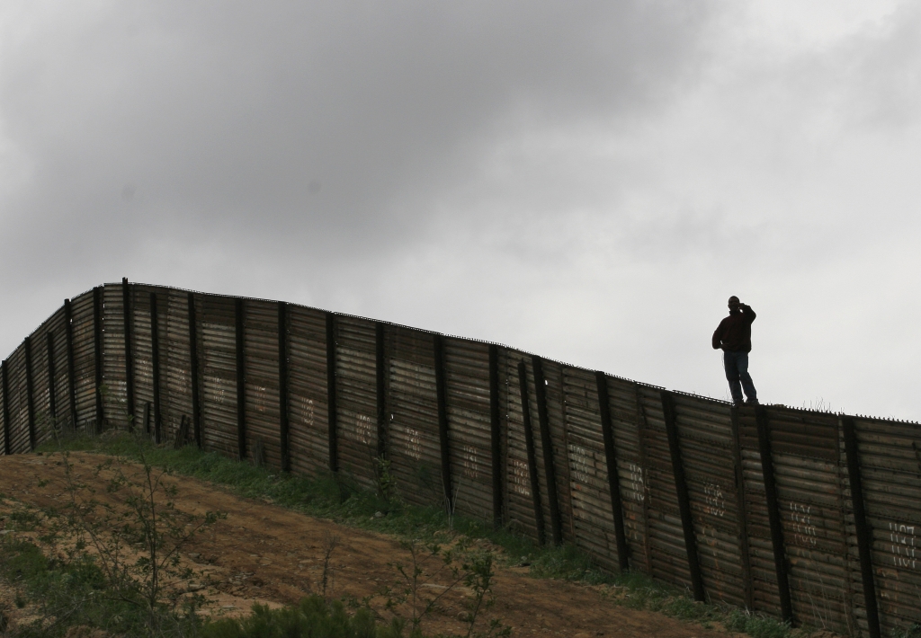 Hermin Ramos of Oaxaca Mexico looks over the U.S.-Mexico border fence near Smuggler's Gulch west of the San Ysidro Port of Entry in San Diego Thursday