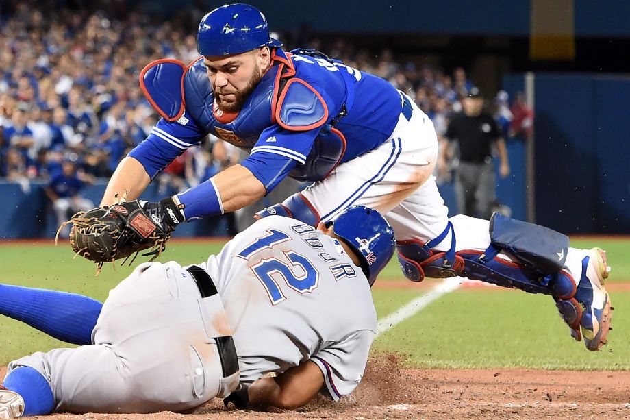 Blue Jays catcher Russell Martin top fails to tag out the Rangers Rougned Odor in the 14th inning