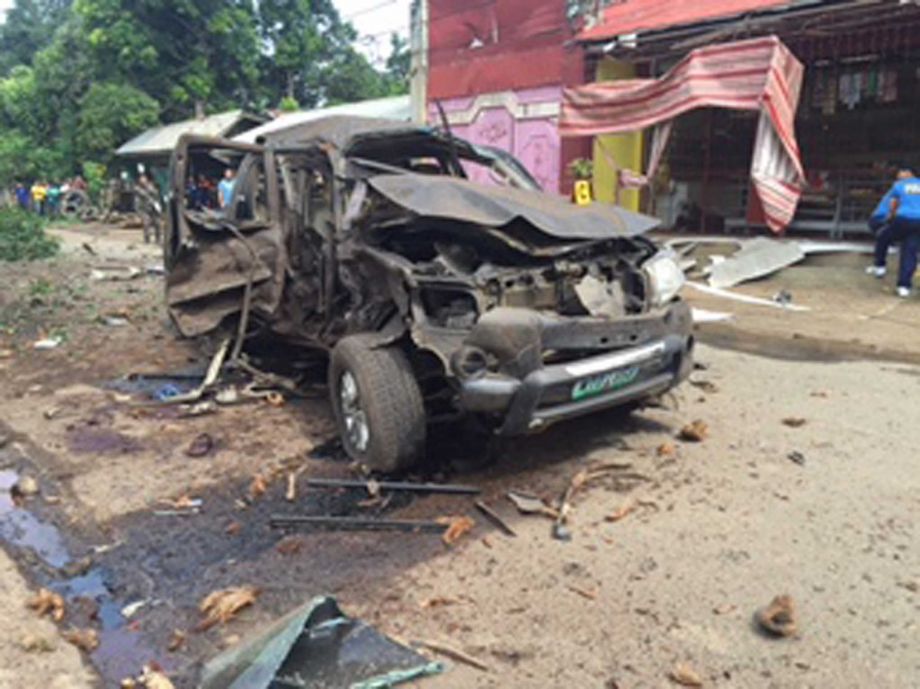 Philippine National Police Basilan a vehicle damaged by a powerful bomb explosion lies along a road in Basilan southern Philippines on Thursday Oct. 1 2015. A powerful bomb hidden in a parked motorcycle exploded and hit