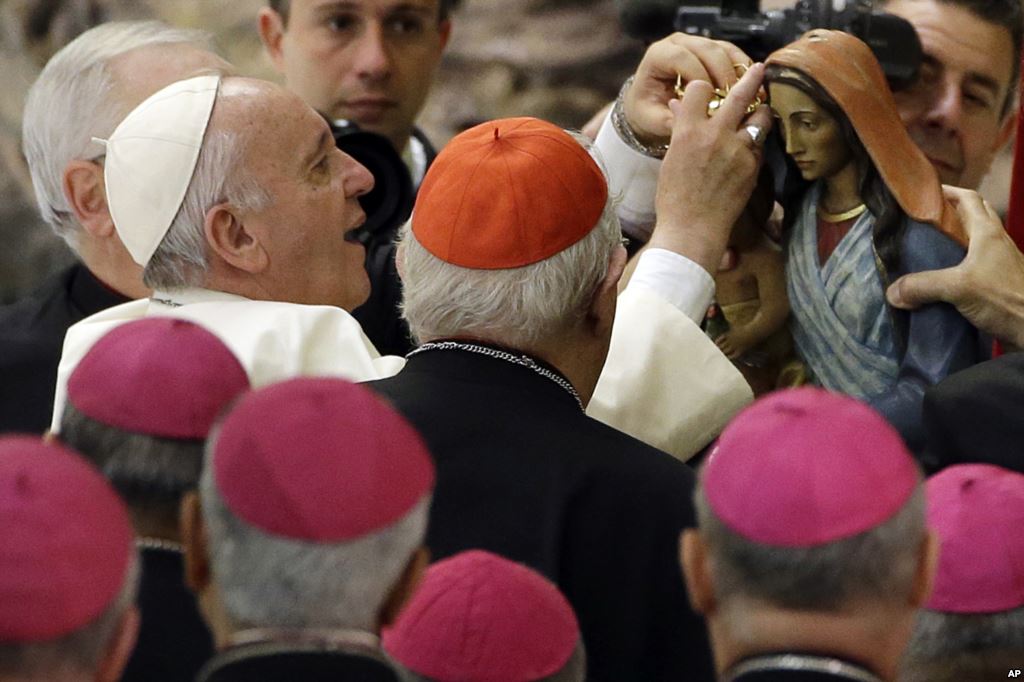 Pope Francis is shown a statuette of the Virgin Mary during an audience with Roma Sinti and others itinerant group members at the Vatican Monday Oct. 26 2015