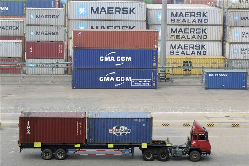 A truck hauls shipping containers in the container pool of a seaport in Qingdao in eastern China's Shandong province. China's imports plunged 20.4 percent from a year earlier to $145.2 billion customs data showed today