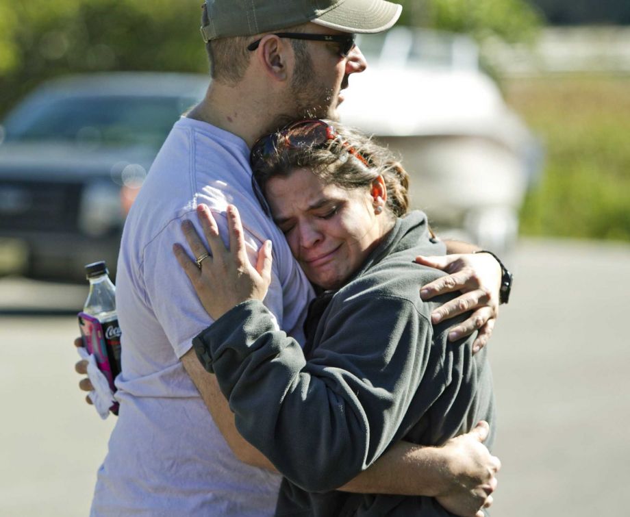 Aaron Juarez's sister Renee Palermo hugs her husband Robert at the Pigeon Lake access site in Port Sheldon Mich. Wednesday Sept. 30 2015. Aaron Juarez and his roommate Chris Thode have been missing after launching a 16-foot pleasure boat from the Pige