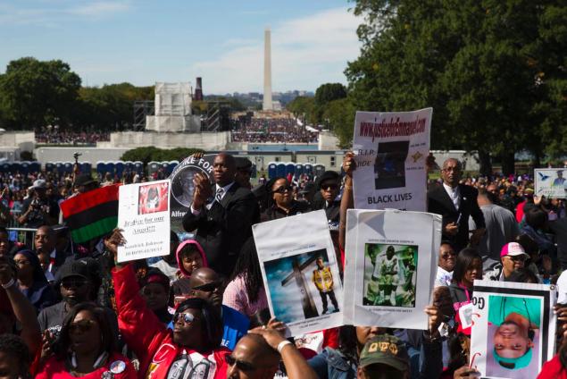 People cheer during the rally to mark the 20th anniversary of the Million Man March on Capitol Hill on Saturday in Washington D.C. Waving flags carrying signs and listening to speeches and songs the crowd gathered at the U.S. Capitol and spread down