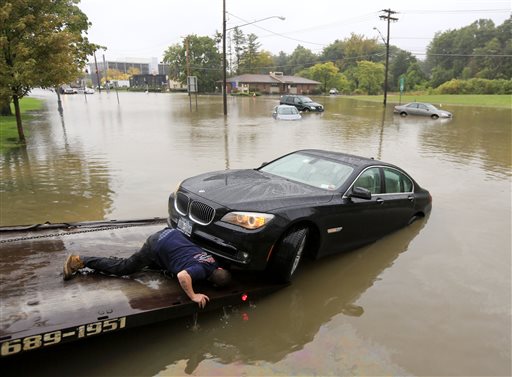 A worker prepares to tow a stranded vehicle from a flooded road on Wednesday Sept. 30 2015 in Guilderland N.Y. The National Weather Service has issued flood watches for much of the eastern half of upstate New York as a storm dumps more than two inches